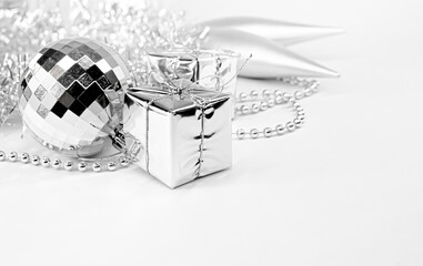Disco ball toy, silver little gifts, shiny tinsel, beads. Christmas decorations on a white...