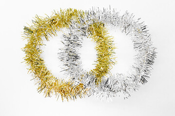 Silver and golden round circles of tinsel. New year decorations on a white background. Christmas...