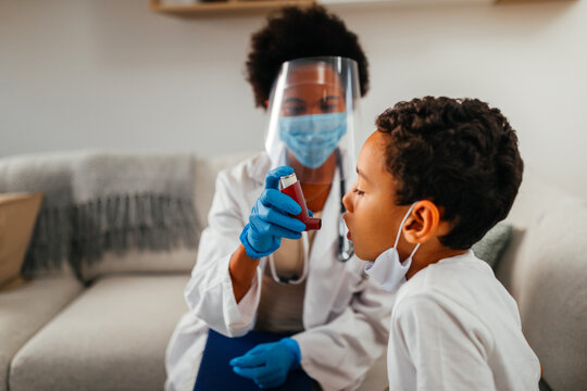 Female Doctor Is Helping Little Boy To Use Asthma Pump