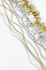 Diagonal silver and golden chain with balls, beads, yellow tinsel. New year decorations on a white background. Christmas concept. Template for text.