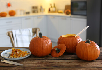 Fresh ripe pumpkins on wooden table in kitchen, space for text. Halloween celebration