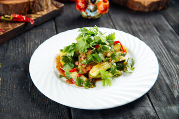 Asian spicy beef salad with greens and cucumbers