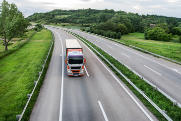 Big transportation truck on an Asphalt highway road or highway closeup against the background of...