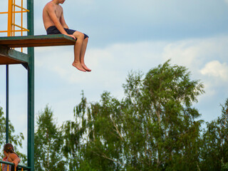 The jump tower. people having fun at summer lake jumping from tower copy space. Young boy jumping into lake. Sport concept
