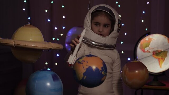 Space Travel Spaceship. Creative Little Girl Astronaut Launching Rocket From Spaceport Through Planets. Child Dreamer Playing Space Rocket Flying Among Planets. Spaceman Fantasy Flying on Spacecraft.