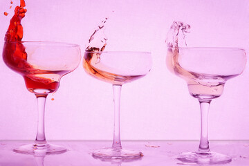 splashes cocktails at bright purple background 