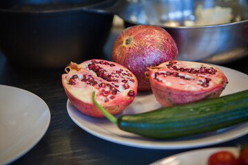 Preparation for cooking: sliced ripe pomegranate and cucumber