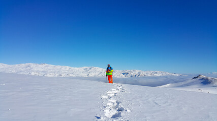 dağlarda bir kayakçı, manzara keyfi, kış mevsimi ve karlı dağlar, renkli giyinen adam