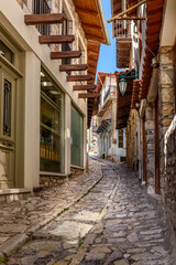Fototapeta premium Traditional architecture in a narrow cobblestoned street in Dimitsana village, Greece.