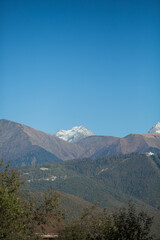 Fototapeta premium snow-capped mountain peaks in autumn against a blue sky