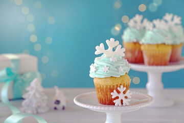 Christmas cupcakes with mint blue cream and white snowflakes.
Christmas decoration table over illumination.　クリスマススノーフレークカップケーキ