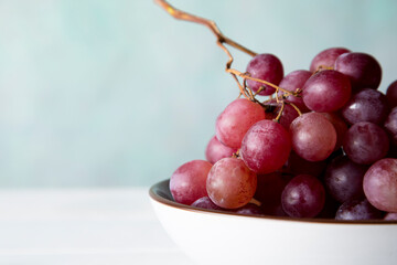 still life of red grapes on white wooden table