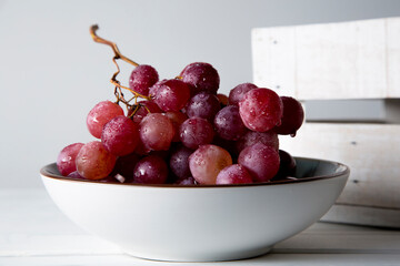still life of red grapes on white wooden table