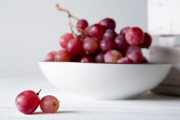 still life of red grapes on white wooden table