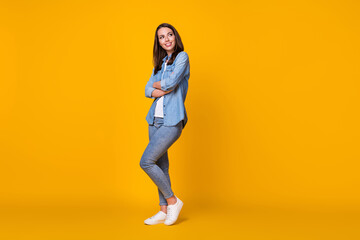 Fototapeta na wymiar Full body profile photo of attractive confident lady arms crossed good mood look dreamy up empty space creative journalist wear casual denim shirt shoes isolated yellow color background