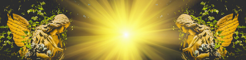 Two gold angels in sunlight. Ancient statues.