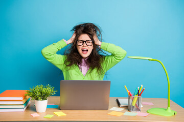 Portrait of overwhelmed girl use laptop work remote touch messy hairstyle isolated over blue color...