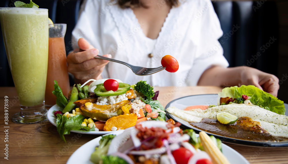 Wall mural selective focus of woman hand with red tomato for diet meal and salad with a healthy food of salad a