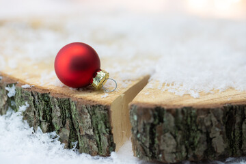 Czerowna bombka w śniegu na drewnianej desce. Dekoracja świąteczna na Boże Narodzenie i Nowy...