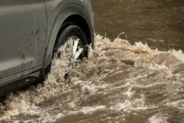 Suv car moving in high-water puddle (selective focus) - obrazy, fototapety, plakaty