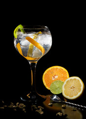 Gintonic cítrico, con naranja, limón y lima en un fonde negro elegante
