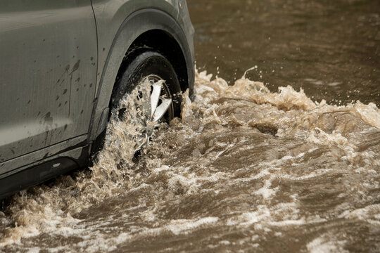 Suv car moving in high-water puddle (selective focus)