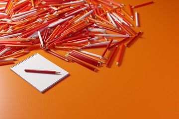 Pencils and sketchbook. Lots of pencils in warm colors next to a blank sketchbook on an orange background. 3D illustration