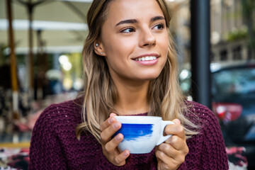 Young woman drinking coffee in the morning at the cafe