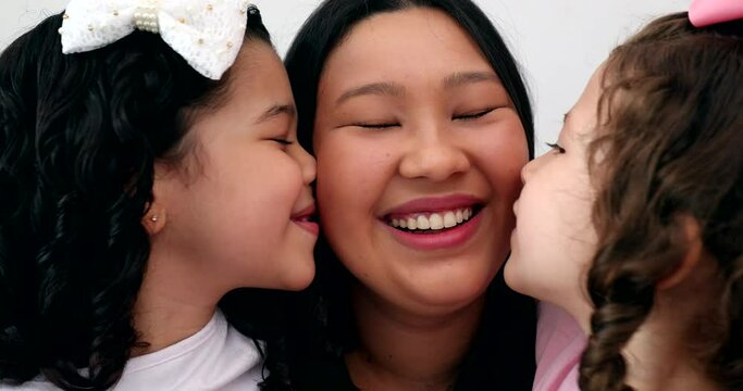 Two little girls kissing mother on the cheek. Asian mom with multi-ethnic daughters, family love and affection