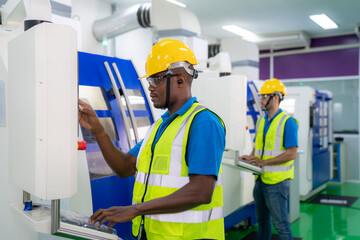 Man worker people wearing protective safety helmet and glasses in production line of factory and operating the high technology machine in industrial plant.