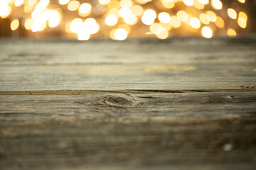 Pusty stół drewniany z rozmytym tłem ze światełkami i lampkami o ciepłej barwie na święta