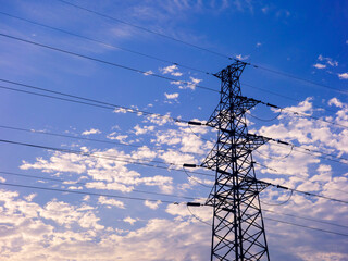 In the early morning, under the background of blue sky and white clouds, the wireless telex tower and the wired electric tower