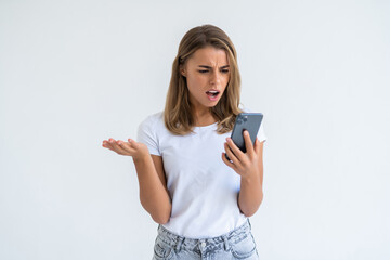 Fototapeta premium Portrait of a confused woman holding mobile phone isolated over white background