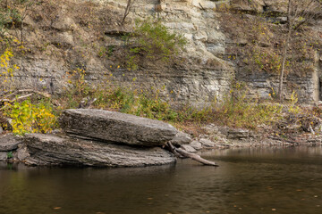 Root River In Autumn - A scenic river next to a cliff.