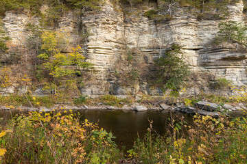Root River In Autumn - A scenic river next to a cliff.