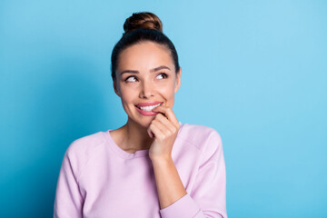 Photo of minded inspired girl touch finger teeth look copyspace think thoughts dream about sweet tasty dessert wear jumper isolated over blue color background