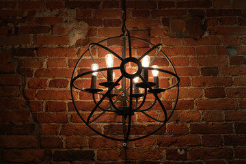 metal chandelier on a brick wall background