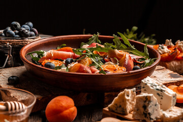 Grilled peach salad with lettuce, blue cheese, prosciutto, dor blue cheese, Delicious breakfast or snack, Close up. Copy space for text
