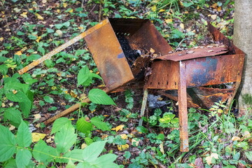 Discarded rusty barbecues pollute the ecology of the forest