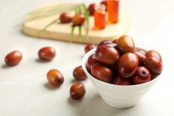 Palm oil fruits in bowl on white table, closeup