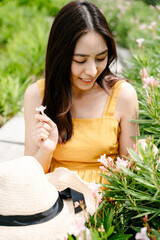 Beautiful asian woman in yellow dress pick up flower in country side farm.