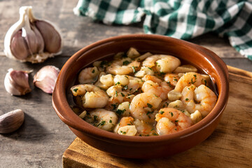 Garlic prawns in crockpot on wooden table	