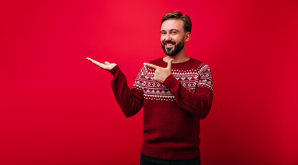 Joyful man in scandinavian sweater laughing in studio. Portrait of good-humoured european guy...