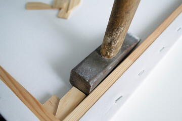 the process of preparing an artistic canvas. The tension of the canvas using special wedges.