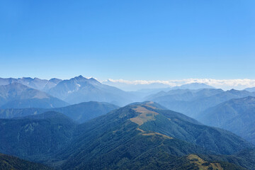 Obraz premium view from the top of Mount Oshten to the ridges of the Caucasus Mountains in a blue haze