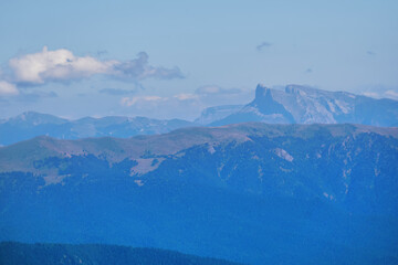 Fototapeta na wymiar view from the mount peak to the mountain ranges on the horizon in a blue haze