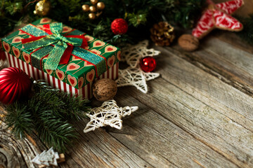 Christmas composition. Christmas gift, Christmas balls, stars, pine cones, fir branches on a wooden background. Top view, copy space