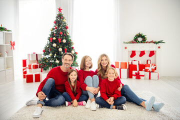 Obraz na płótnie Canvas Full length photo of big family five people gathering three little kids cuddle sit carpet wear red jumper jeans in living room x-mas preparation evergreen tree gift boxes indoors