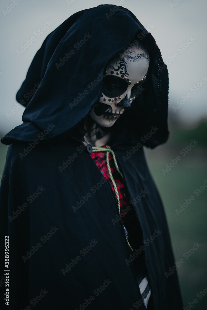 Wall mural Portrait of woman in Halloween costume of death with painted skeleton on her body and sugar skull makeup.