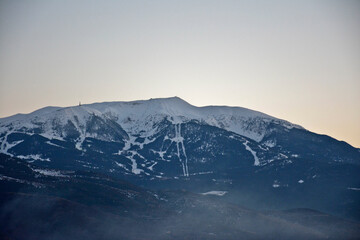 Fototapeta na wymiar Ski resort seen from afar on a beautiful mountain at sunset time